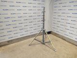 an image of a tripod stands in front of a wall with a sign