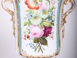 a vase with flowers painted on it sitting on a stand
