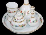 a picture of a white and gold tea set on a plate
