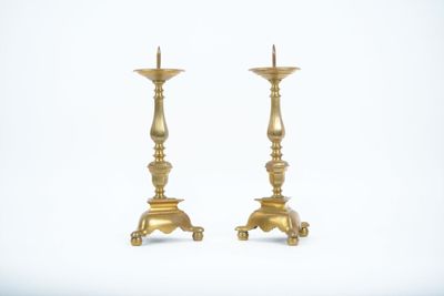 pair of antique brass candlesticks on a white background