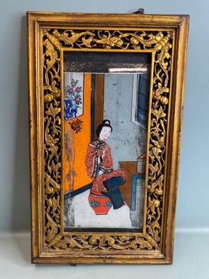 une vieille photo d'une femme en robe rouge assise devant un miroir