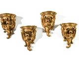 three gold colored wall sconces with a lion head on each of them