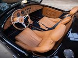 the interior of a black sports car with tan leather seats and a steering wheel