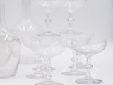 a lot of wine glasses and a bottle on the table