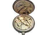a pocket watch that is sitting on a white surface