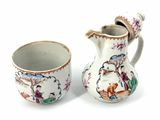 a small pitcher and a small cup sitting next to each other