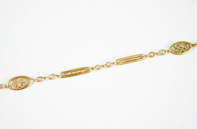 a gold plated bracelet with a coin on a chain