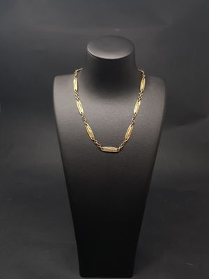 un collier à chaîne en or sur un mannequin, sur fond noir