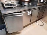 plan de travail en acier inoxydable dans une cuisine professionnelle équipée d'un micro-ondes et d'un lave-vaisselle
