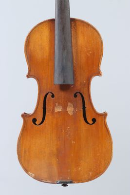 an old violin sitting on a stand against a white background