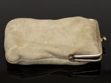 a white stone with a metal clasp on a black surface