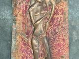 bronze relief of a man holding a fan on a wall