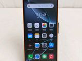 l'arrière d'un téléphone portable noir et orange posé sur une surface blanche