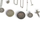 many different types of coins and charms on a white surface