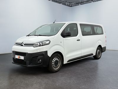 the white van is parked in a large room with a black floor