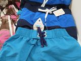 three men ' s swim trunks are lined up on a table