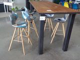 des tables et des tabourets dans une grande pièce où se trouvent de nombreuses chaises