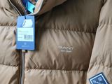 the jacket is tan and has a blue tag on it