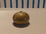 a small ceramic object sitting on a white table