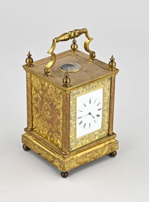 a gold clock with a bird on top of it
