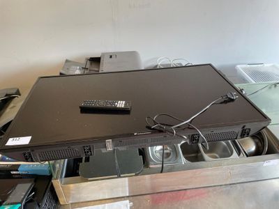 un téléviseur posé sur une table, avec une télécommande