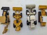 five toy vehicles that are lined up on a white surface