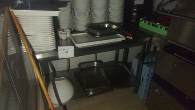several plates and pans are stacked on a shelf in a kitchen