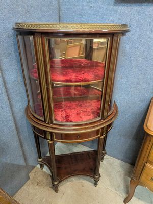 une vitrine en verre contenant une chaise rouge