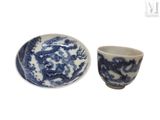 une tasse et une soucoupe bleues et blanches posées l'une à côté de l'autre