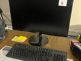 un écran d'ordinateur et un clavier posés sur un bureau dans un bureau