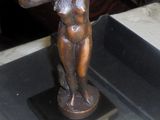 une statue en bronze représentant une femme tenant une fleur
