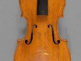 an old violin with a black bow on a gray background