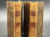 pair of antique leather bound bookends with red and gold bindings