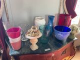many different colored glass vases on a table