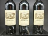 trois bouteilles de vin sont posées sur une boîte noire