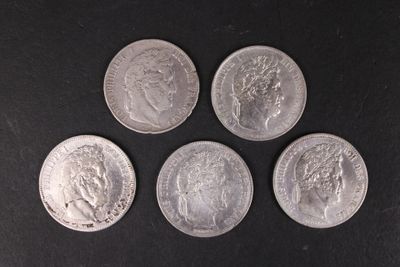 quatre pièces d'argent empilées les unes sur les autres sur une surface noire