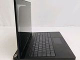 a laptop with a black keyboard on a white surface