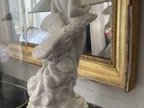 a statue of a woman holding a surfboard on a table