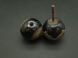 two black and gold apples sitting on a table
