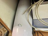 a white air conditioner sitting on the floor next to a wall