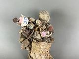 figurine of a basket full of stuffed animals on a gray surface