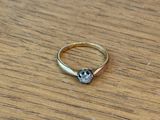 a ring that has a skull on it on a wooden table