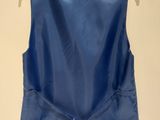 the back of a blue vest on a hanger on a wall