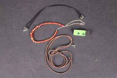 un collier orné d'une perle rouge et d'une étiquette verte