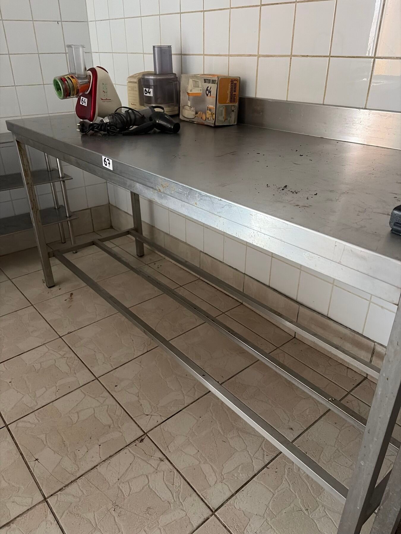 Une table inox avec dosseret et entre jambe.