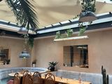tables and chairs in a restaurant with a skylight above them