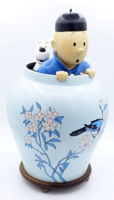 un petit vase bleu dans lequel se trouvent un garçon et un chien