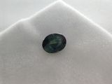 a close up of a green sapphire stone on a white cloth