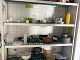 many pots and pans on the shelves in the kitchen