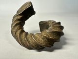 une image représentant une sculpture en bronze d'un objet en forme de spirale posée sur une surface blanche